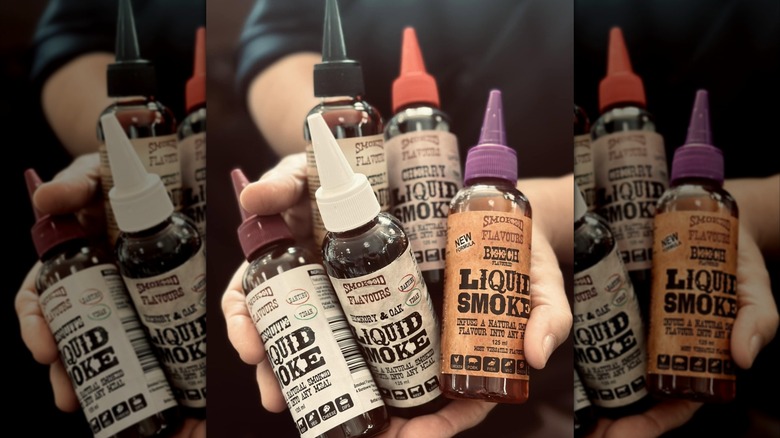 Liquid smoke bottles in someone's hands