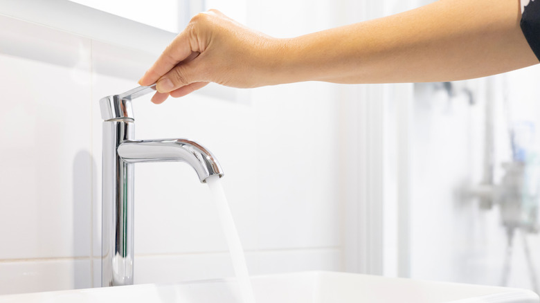 hand turning on a tap