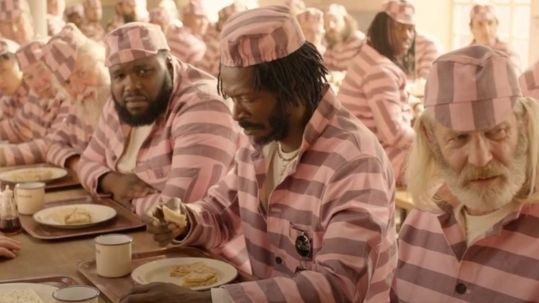 man in pink jail suit with marmalade sandwich in hand