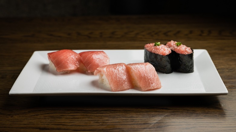 Three sets of nigiri on a white platter