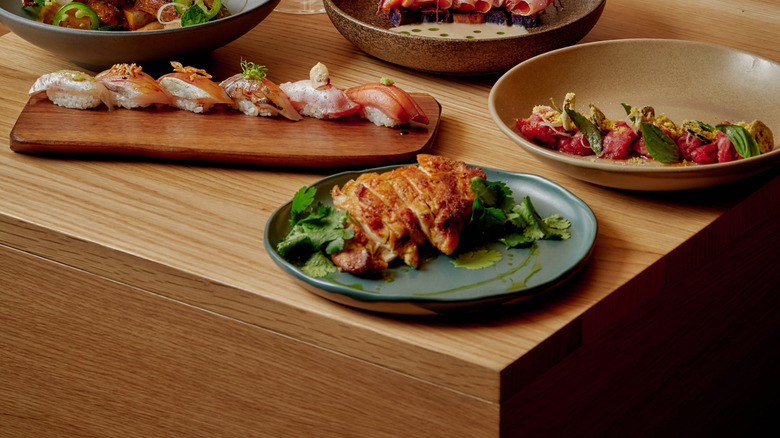 Various plates from Uchi West Hollywood on a wooden board