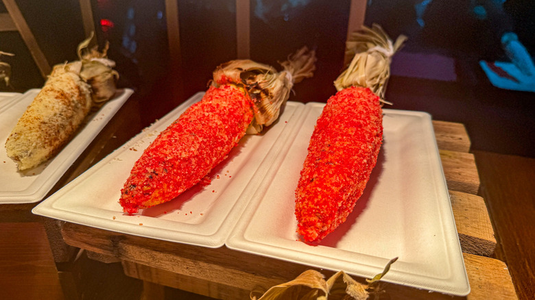Ears of elote corn coated in red Flamin' Hot Cheeto dust