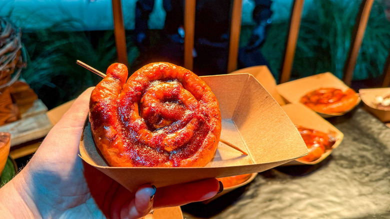 Spiral sausage on a stick in a cardboard takeout box