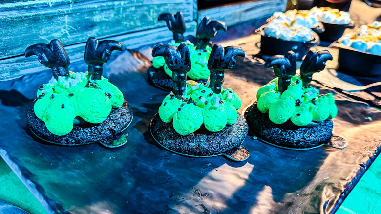 Chocolate cookies topped with green icing and witch legs decorations