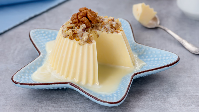 Vanilla Bavarian cream on a blue, star-shaped plate garnished with walnuts