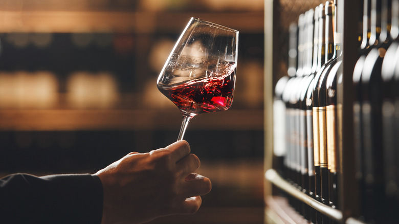 Hand swirls glass of red wine