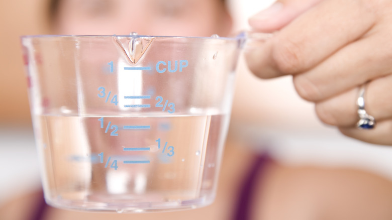 Close up of someone filling a measuring cup