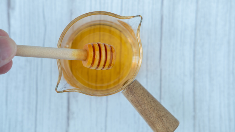 Honey being poured into a measuring cup