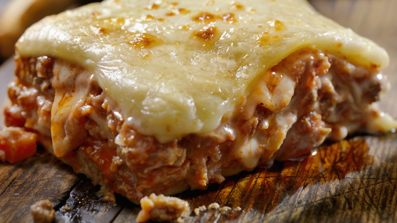 cheesy meat lasagne on wooden board