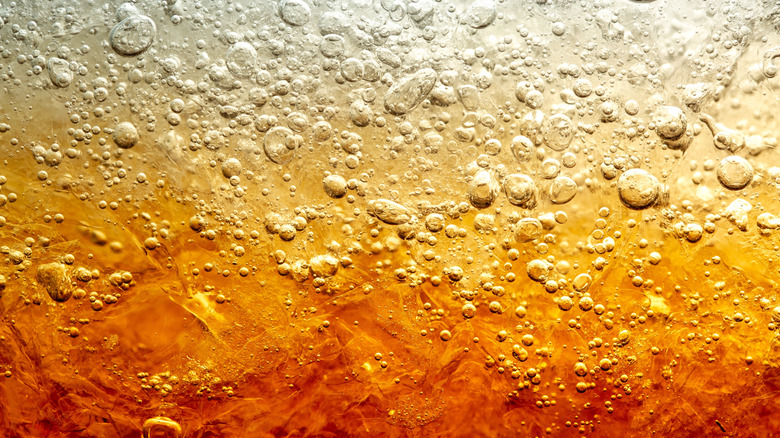 A close up of bubbles in brown soda