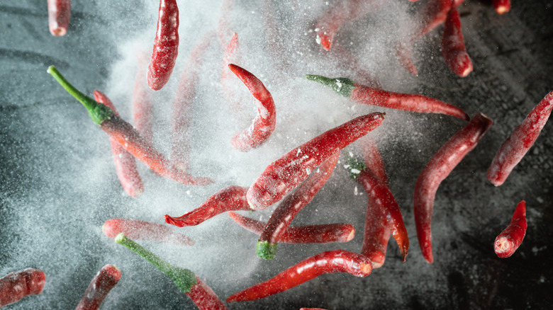 Chili peppers airborne in misty cloud