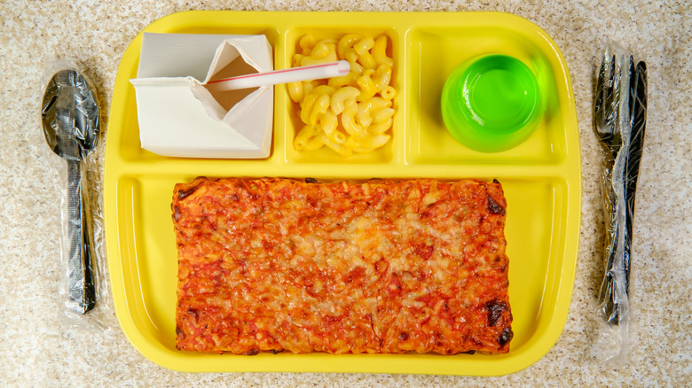 Rectange pizza, mac and cheese, milk, and gelatin on a yellow lunch tray