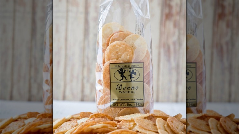 Bag of benne wafers with many cookies piled around it