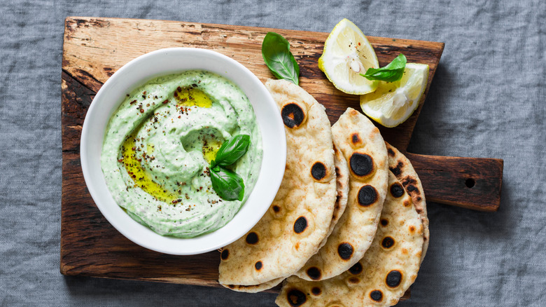 Green goddess dip with pita on a wooden board