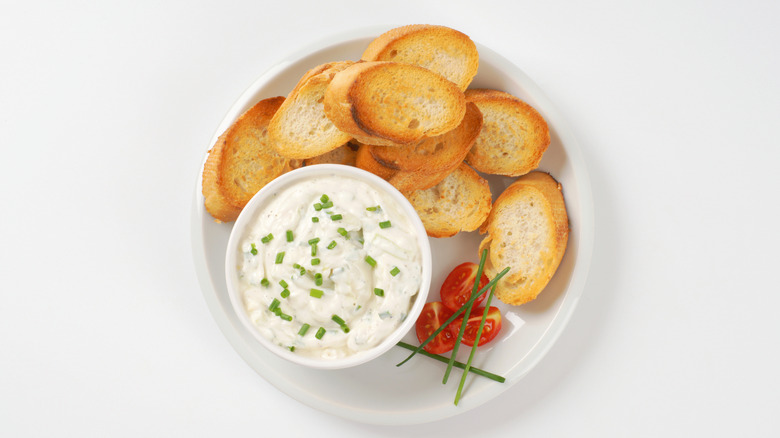 Top down view of dip in a blue bowl, pita bread on the side