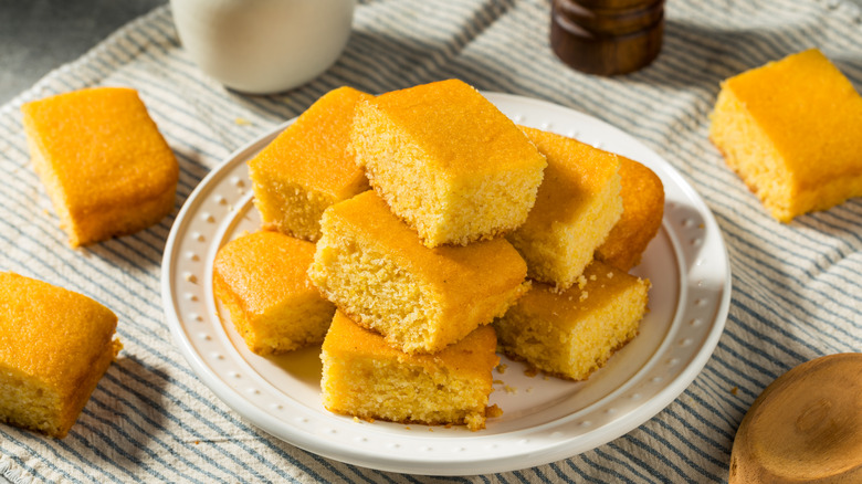 Pile of cornbread slices on white plate