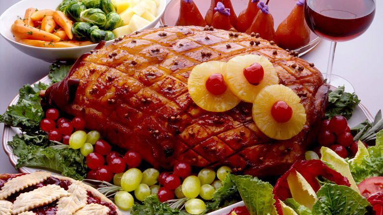 A roasted ham with pineapple and cherries