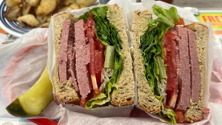 A liverwurst sandwich with lettuce and tomatoes