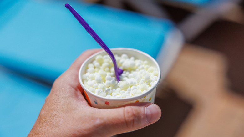 A person holding a cup of Dippin' Dots