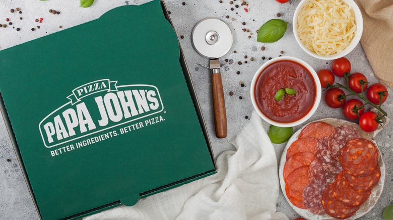 Papa John's pizza box with fresh ingredients on the side