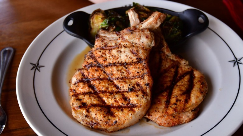 Two bourbon-glazed pork chops on a plate at Saltgrass Steakhouse