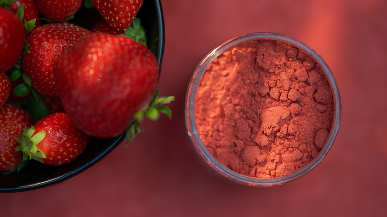 bowl of freeze-dried and fresh strawberries pink background