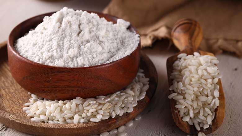wooden bowl with rice flour and raw rice