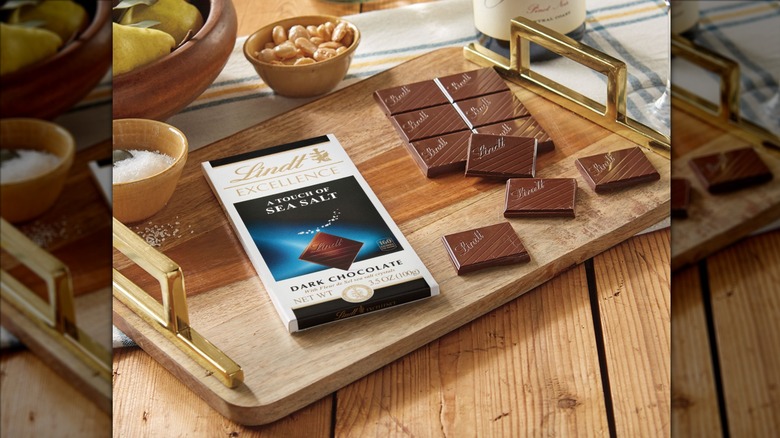 Bar of Lindt Excellence dark chocolate with sea salt on a wooden cutting board