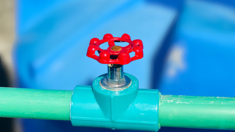 Red stop valve on green pipe