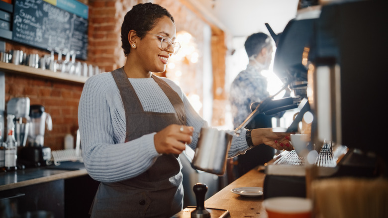 Person making coffee in coffee shop