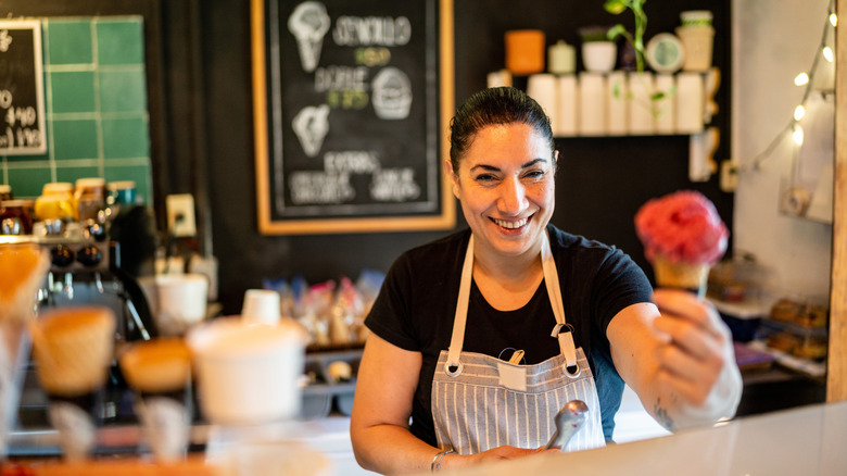 Person handing customer an ice cream cone