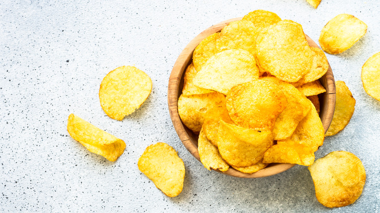 Overhead view of wooden bowl full of potato chips
