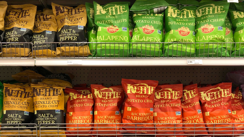 Grocery store shelves lined with various flavors of Kettle Brand Potato Chips