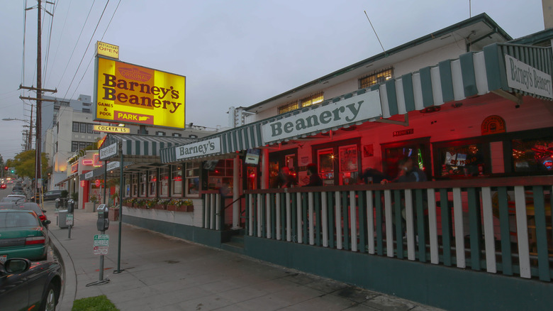 Barney's Beanery front at dusk with sign lit up