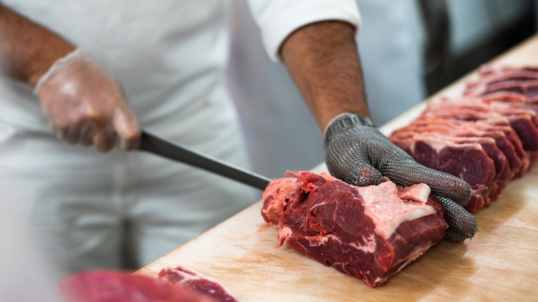 Close up of butcher cutting steak