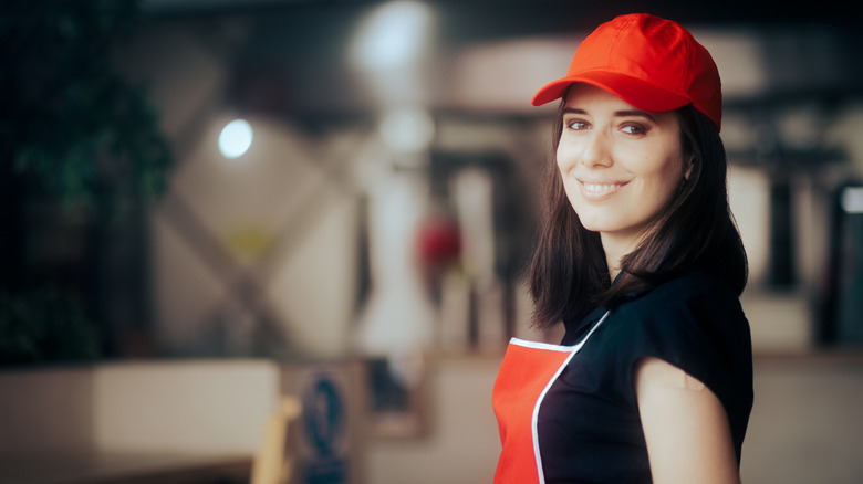 Restaurant worker smiling in a welcoming fashion