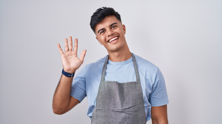 Maler server smiling and waving