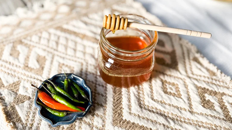 Hot honey in a container with chili peppers