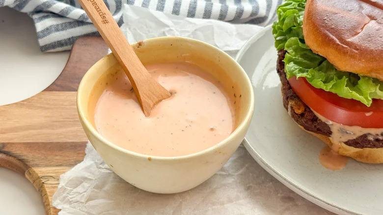 Smash burger sauce in a container with a burger