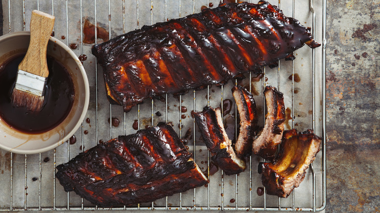 Ribs on a wire rack coated with thick barbecue sauce