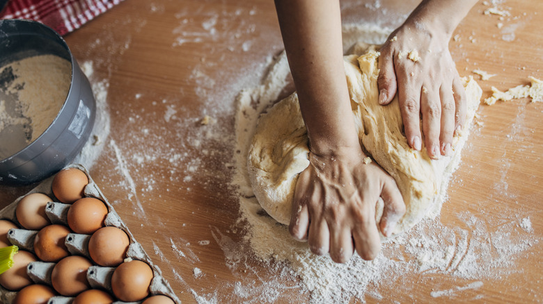 Person stretching out dough with hands