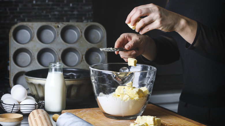 Person cutting up butter for pie crust