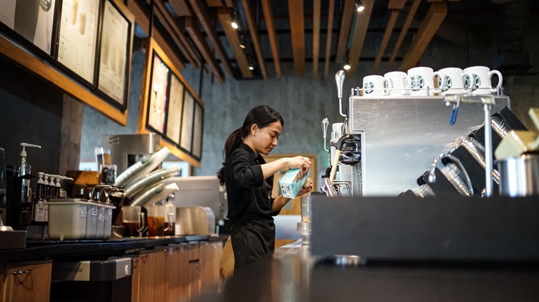A Starbucks barista prepares a beverage.