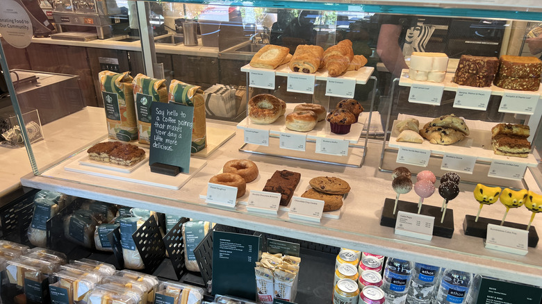 Various Starbucks food items are displayed in a glass case.