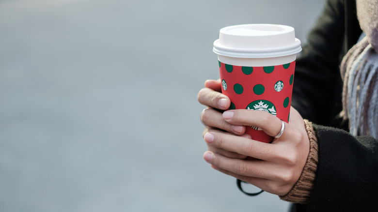 A Starbucks customer holds a cup from the coffee chain.