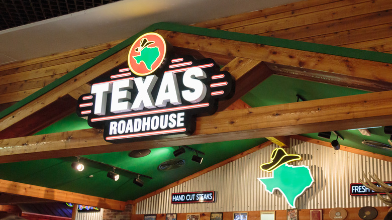 Interior of a Texas Roadhouse restaurant, showing customers and staff at tables