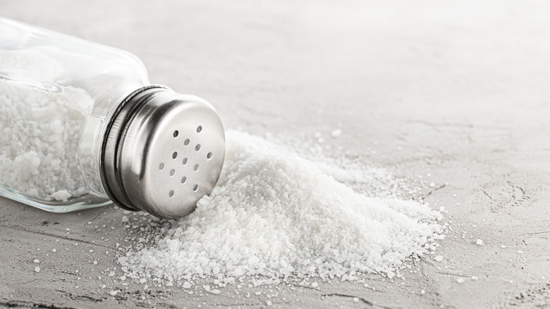Salt shaker pouring onto counter