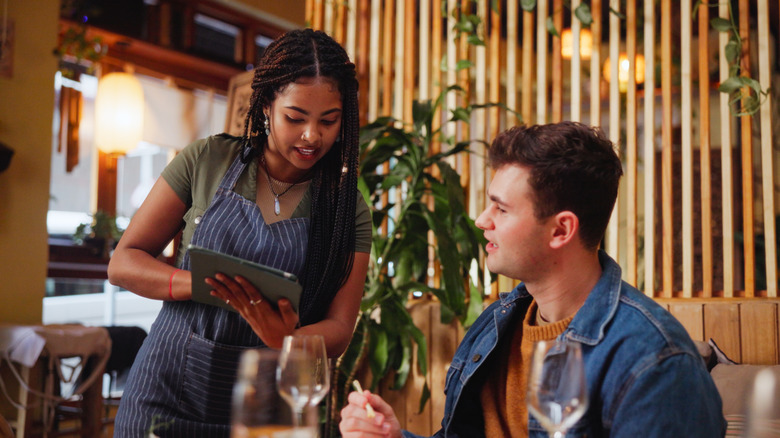 Man ordering from a server with a tablet
