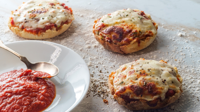 English muffin pizza with bowl of of sauce