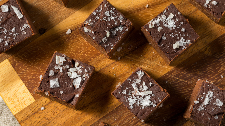 Chocolate fudge with salt flakes on a wooden platter